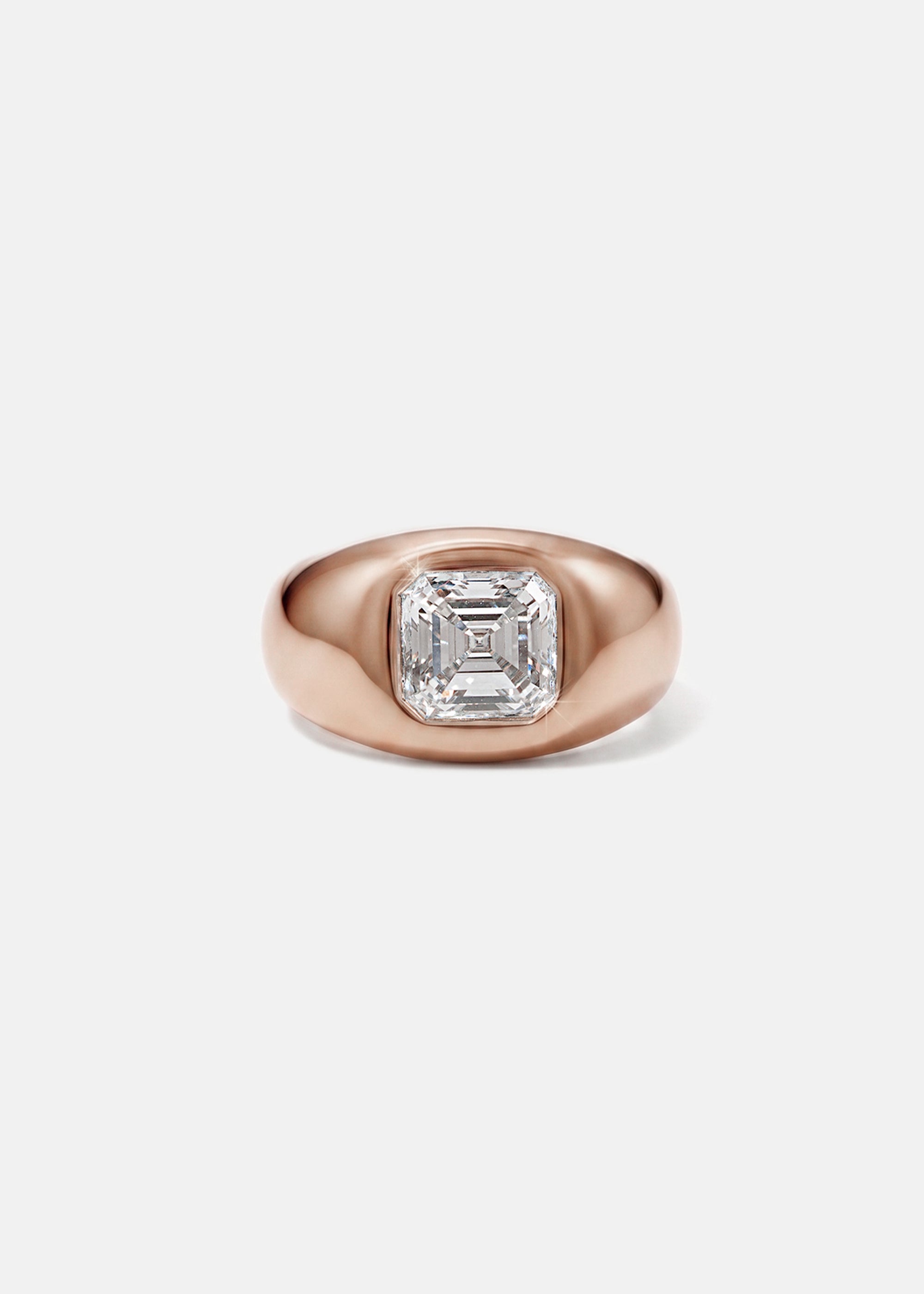A 18k rose gold signet ring featuring a large, bezel-set asscher cut diamond, against a clean background.