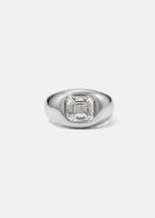 A 18k white gold signet ring featuring a large, bezel-set asscher cut diamond, against a clean background.