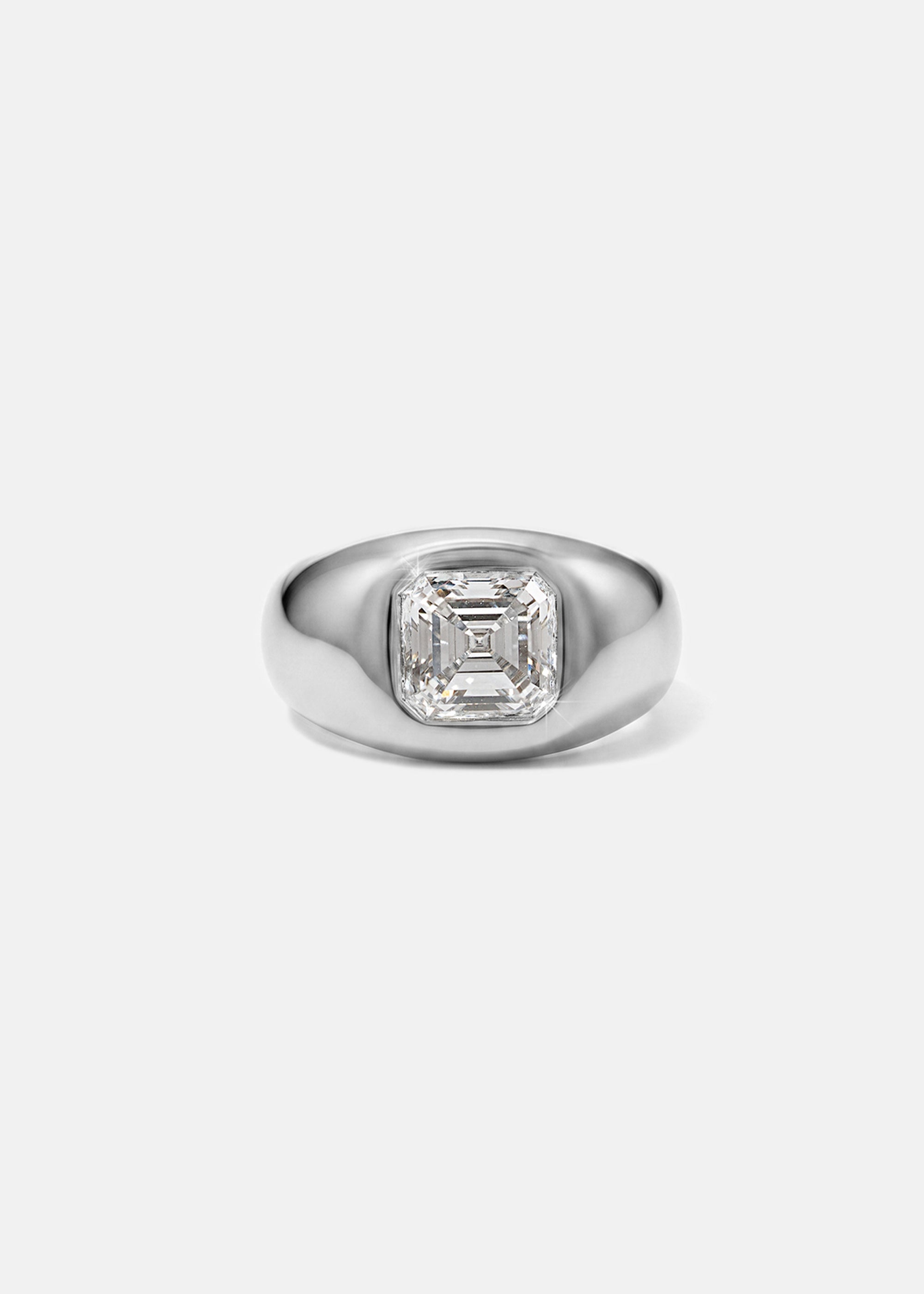 A 18k white gold signet ring featuring a large, bezel-set asscher cut diamond, against a clean background.