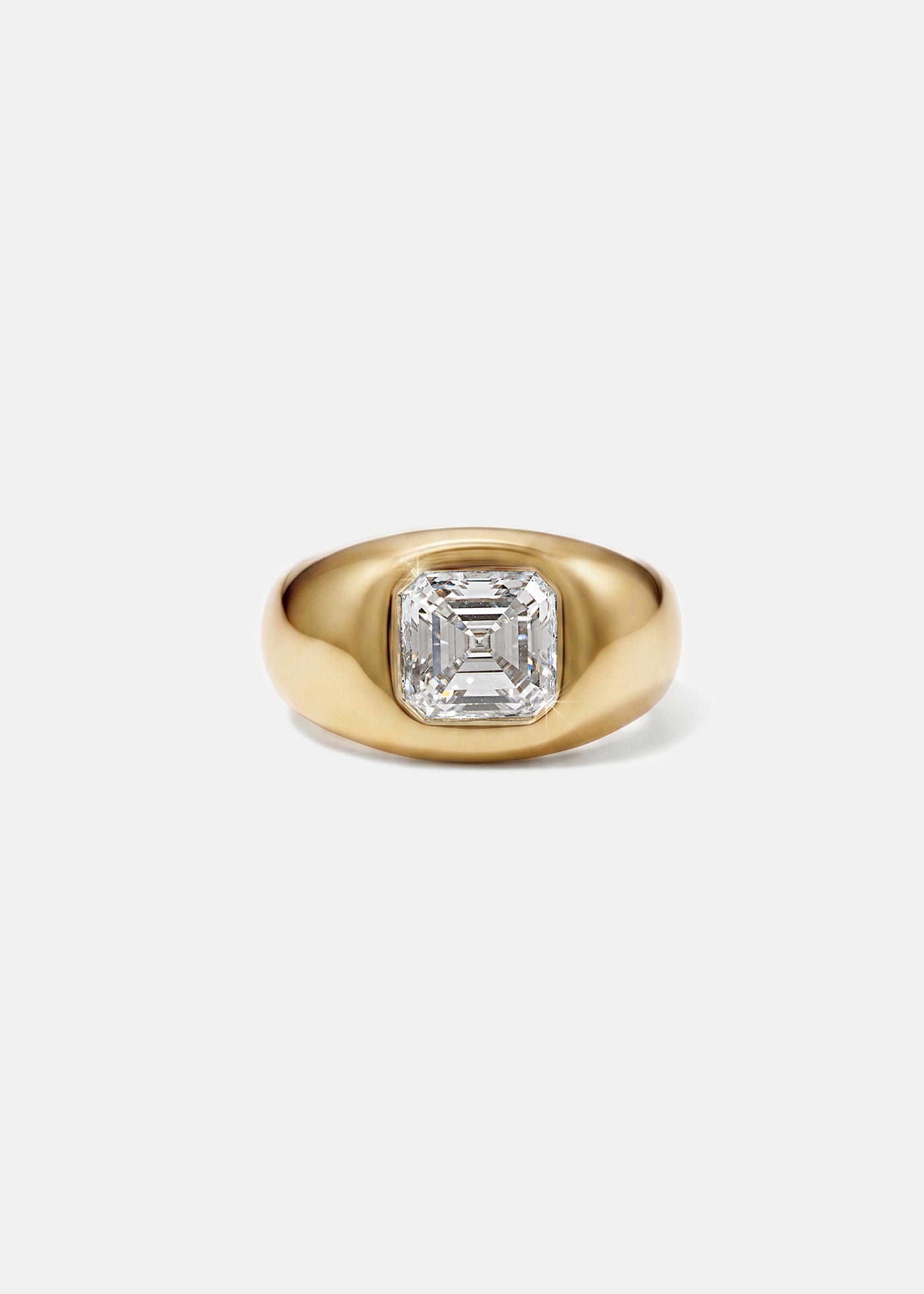A 18k yellow gold signet ring featuring a large, bezel-set asscher cut diamond, against a clean background.