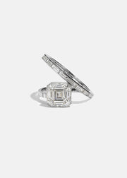 18k white gold bypass ring featuring a floating asscher cut diamond and tapering channel of baguettes band.