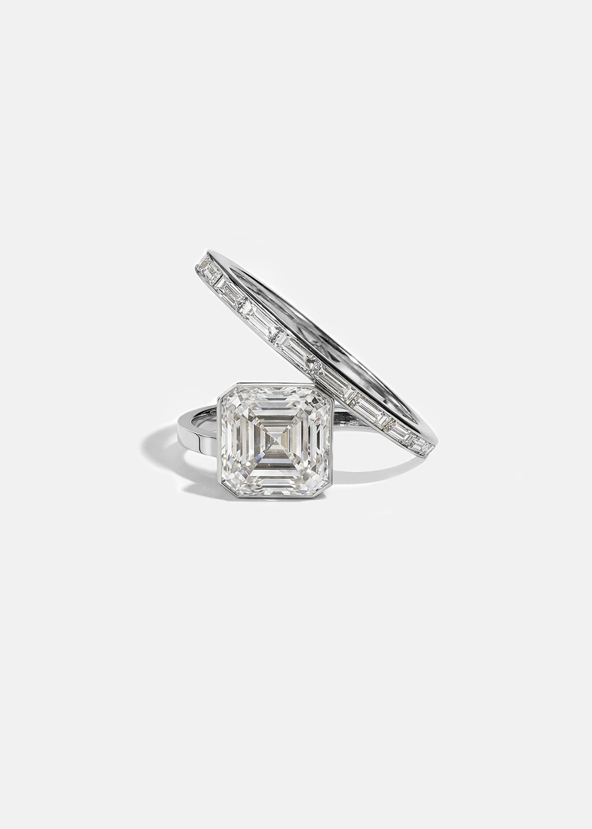 18k white gold bypass ring featuring a floating asscher cut diamond and tapering channel of baguettes band.