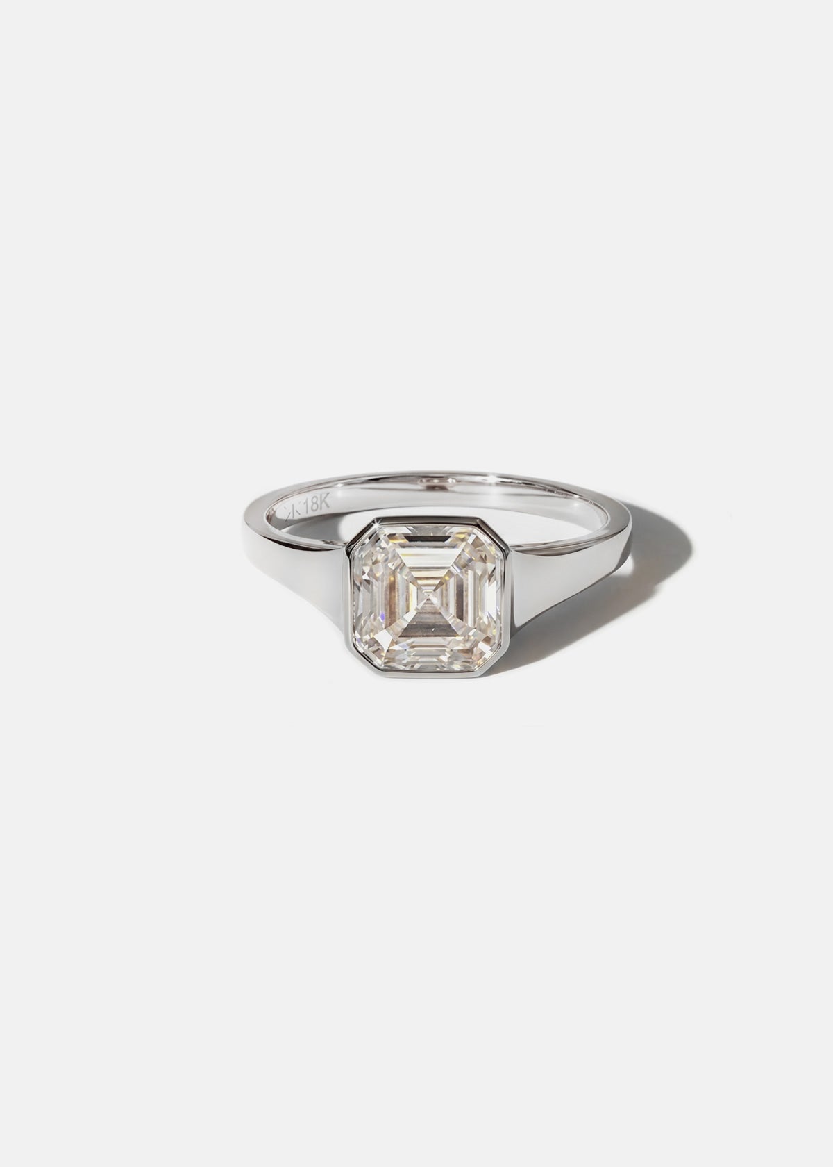 18k white gold tapering gold band - with a bezel set asscher cut diamond 