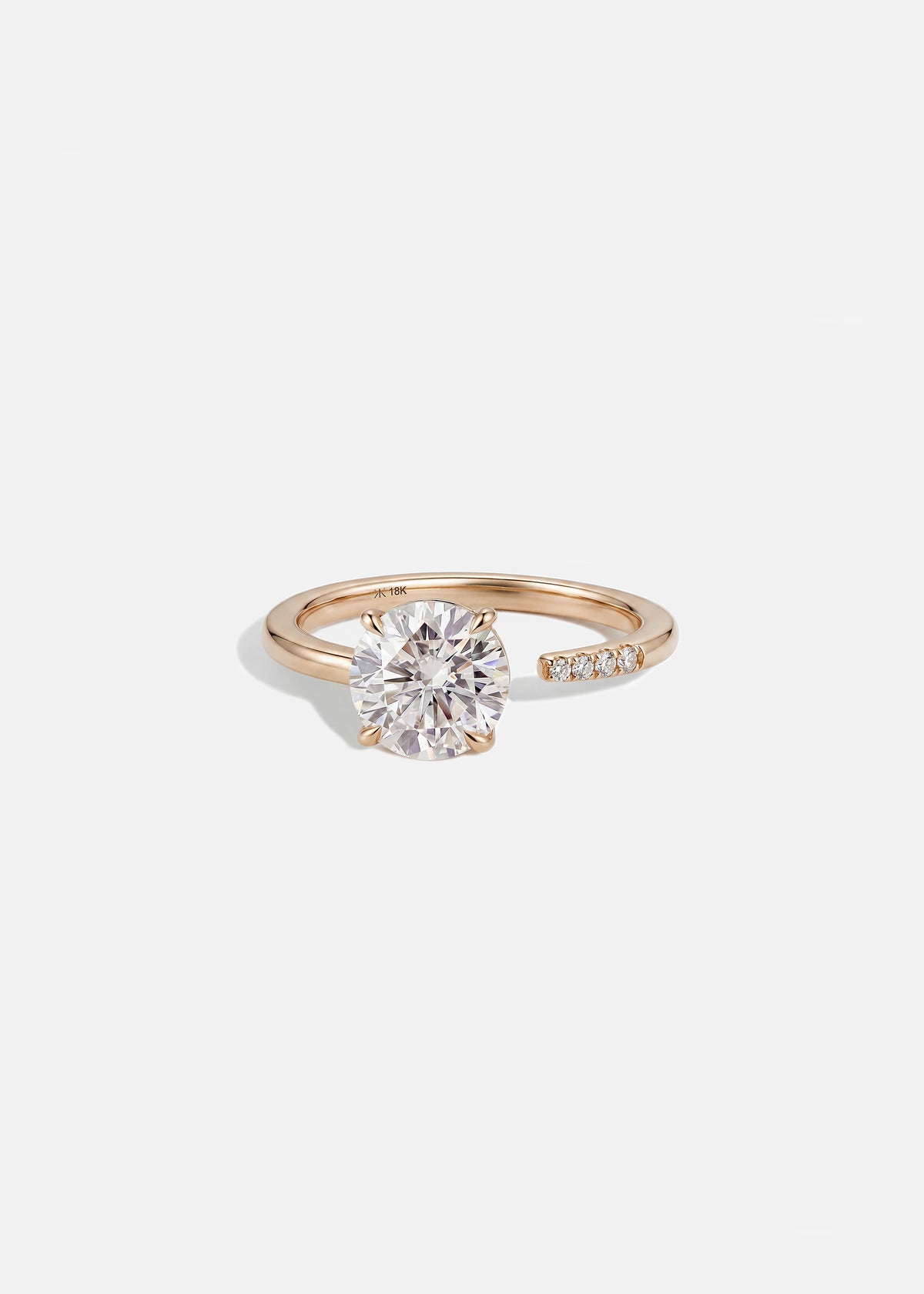 18k rose gold solitaire engagement ring featuring a floating round brilliant diamond on a fluid, tapering open band
