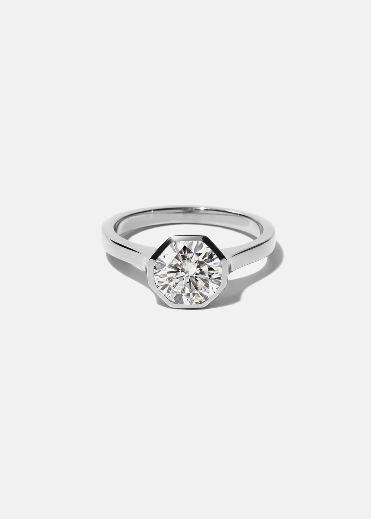 18k white gold architectural engagement ring with a round cut diamond in a thick, octagon bezel setting.