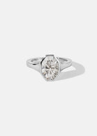 18k white gold engagement ring featuring an oval cut diamond in a sculpted octagonal bezel frame.