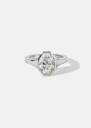 18k white gold engagement ring featuring an oval cut diamond in a sculpted octagonal bezel frame.