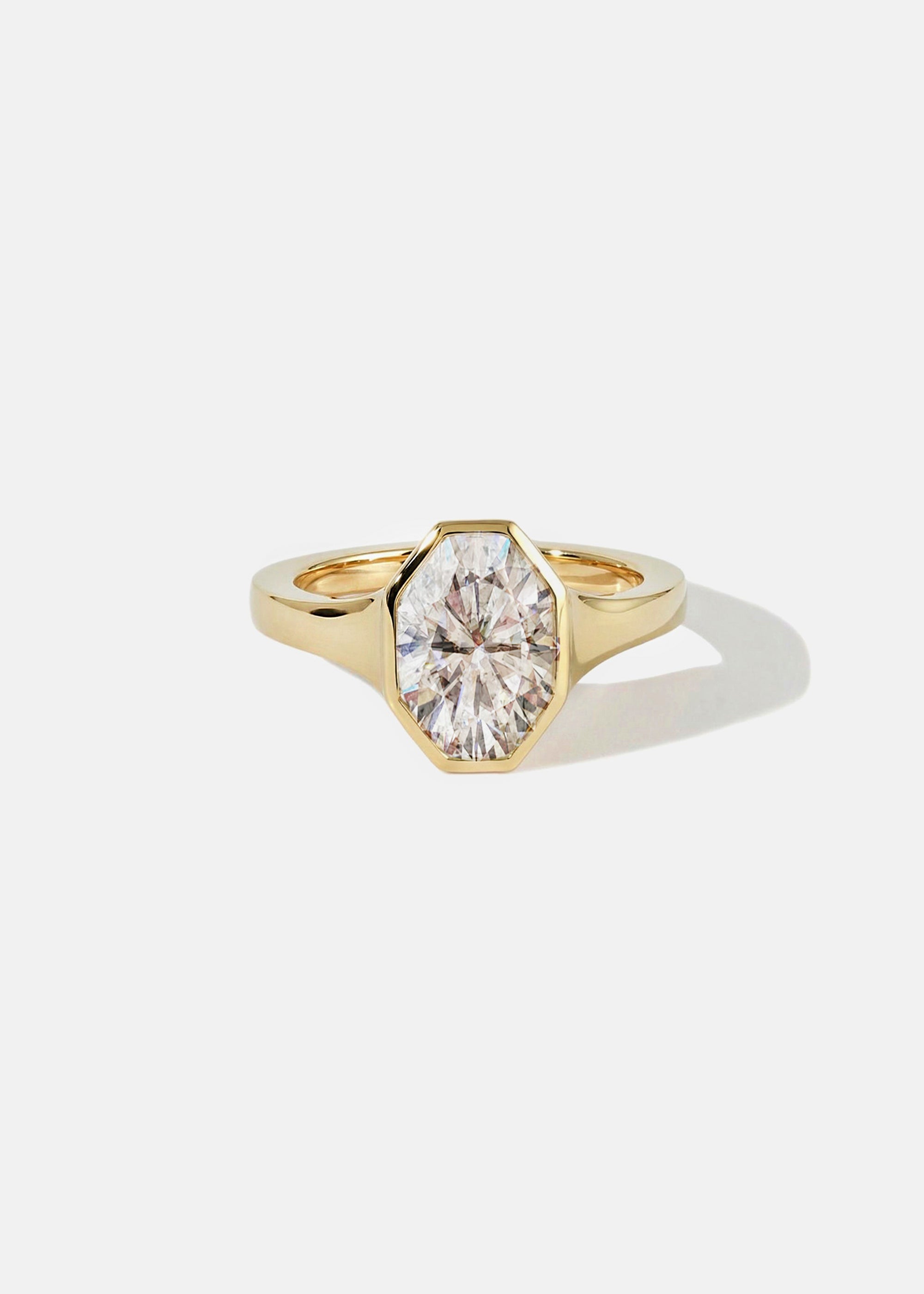 18k yellow gold engagement ring featuring an oval cut diamond in a sculpted octagonal bezel frame.