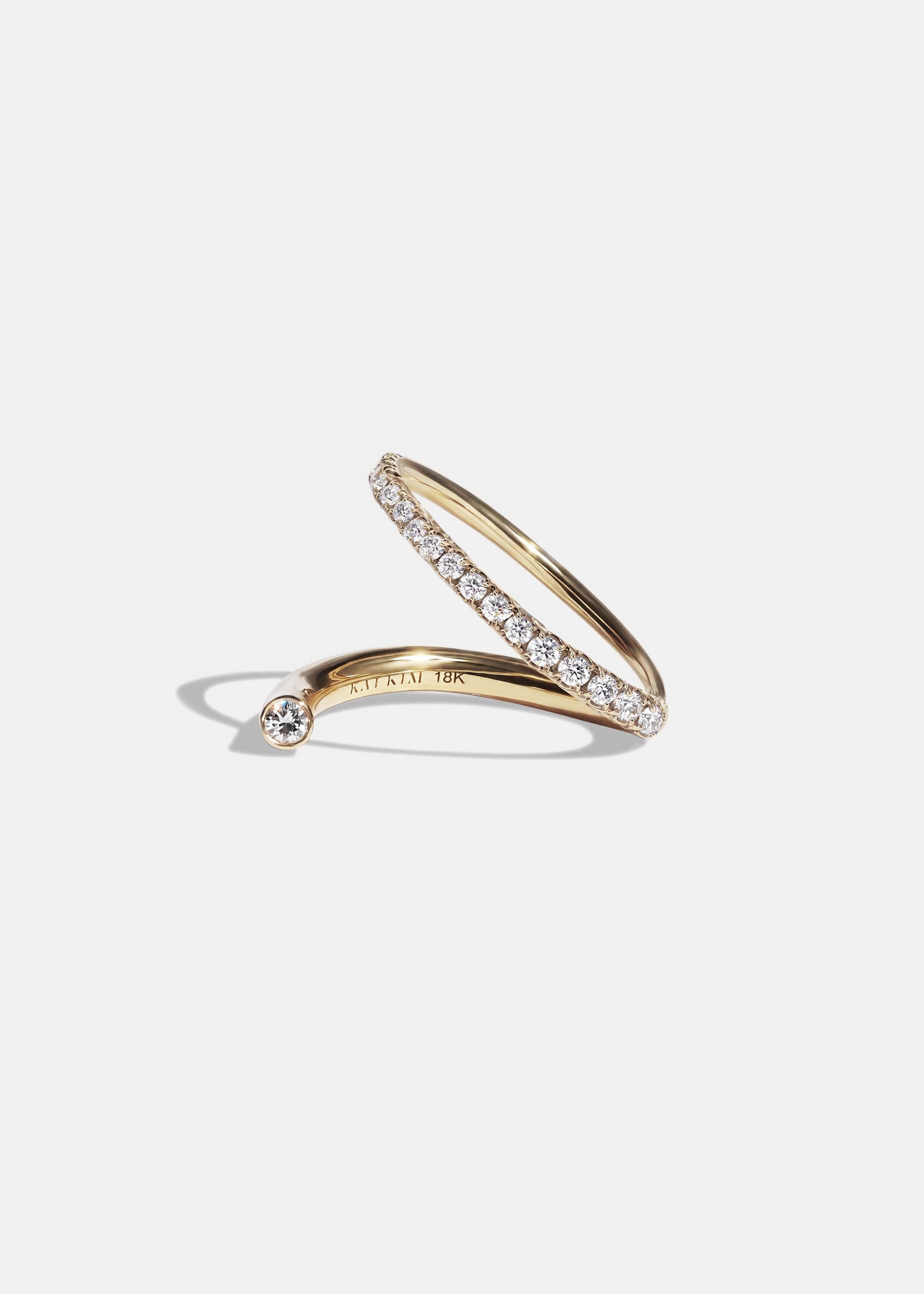 KATKIM 18k yellow gold Crescendo Flare Ring featuring a small floating diamond on a wrapping band.