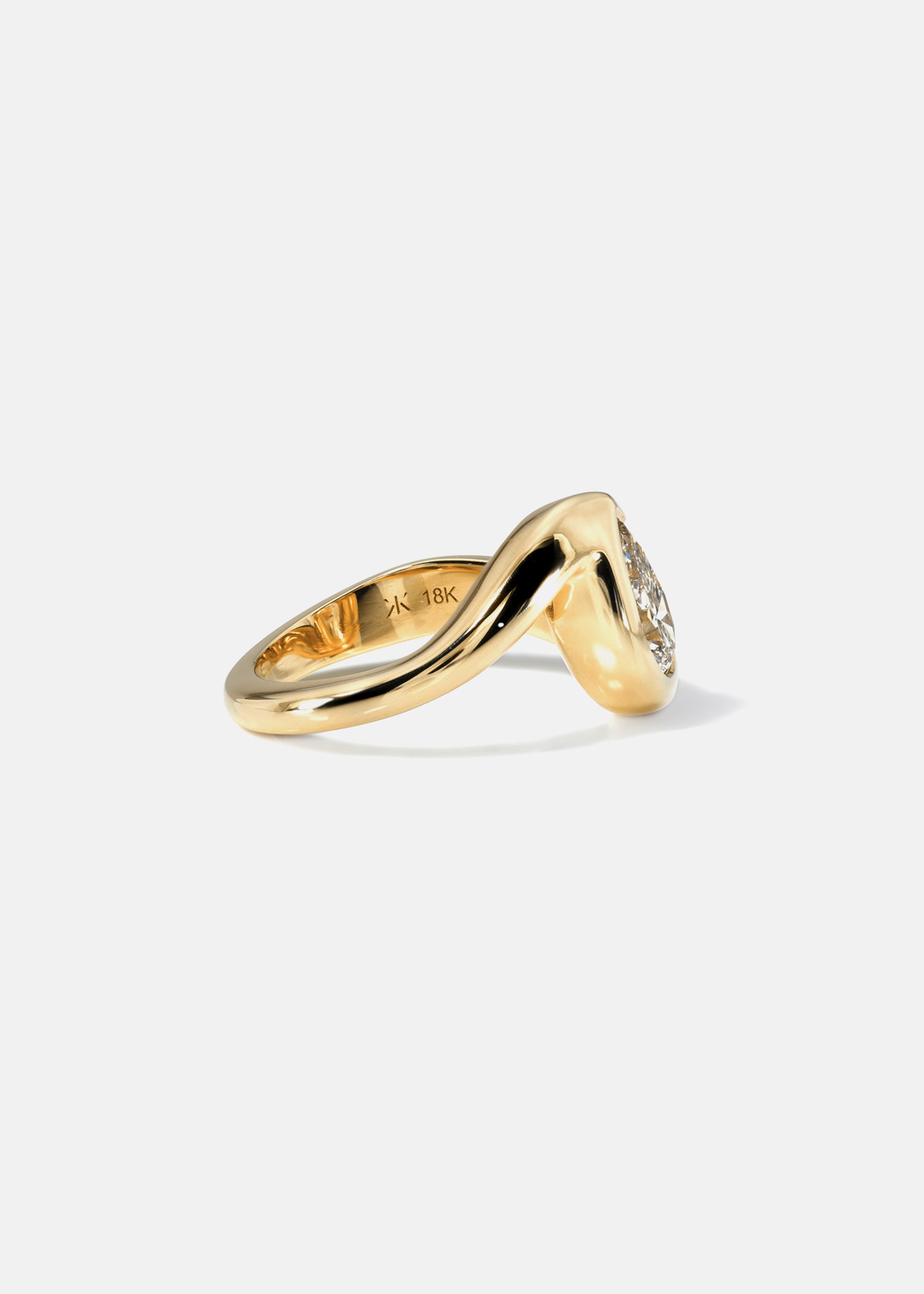 18k yellow gold ring featuring a pear-cut diamond in a curved, wave-like setting- side view