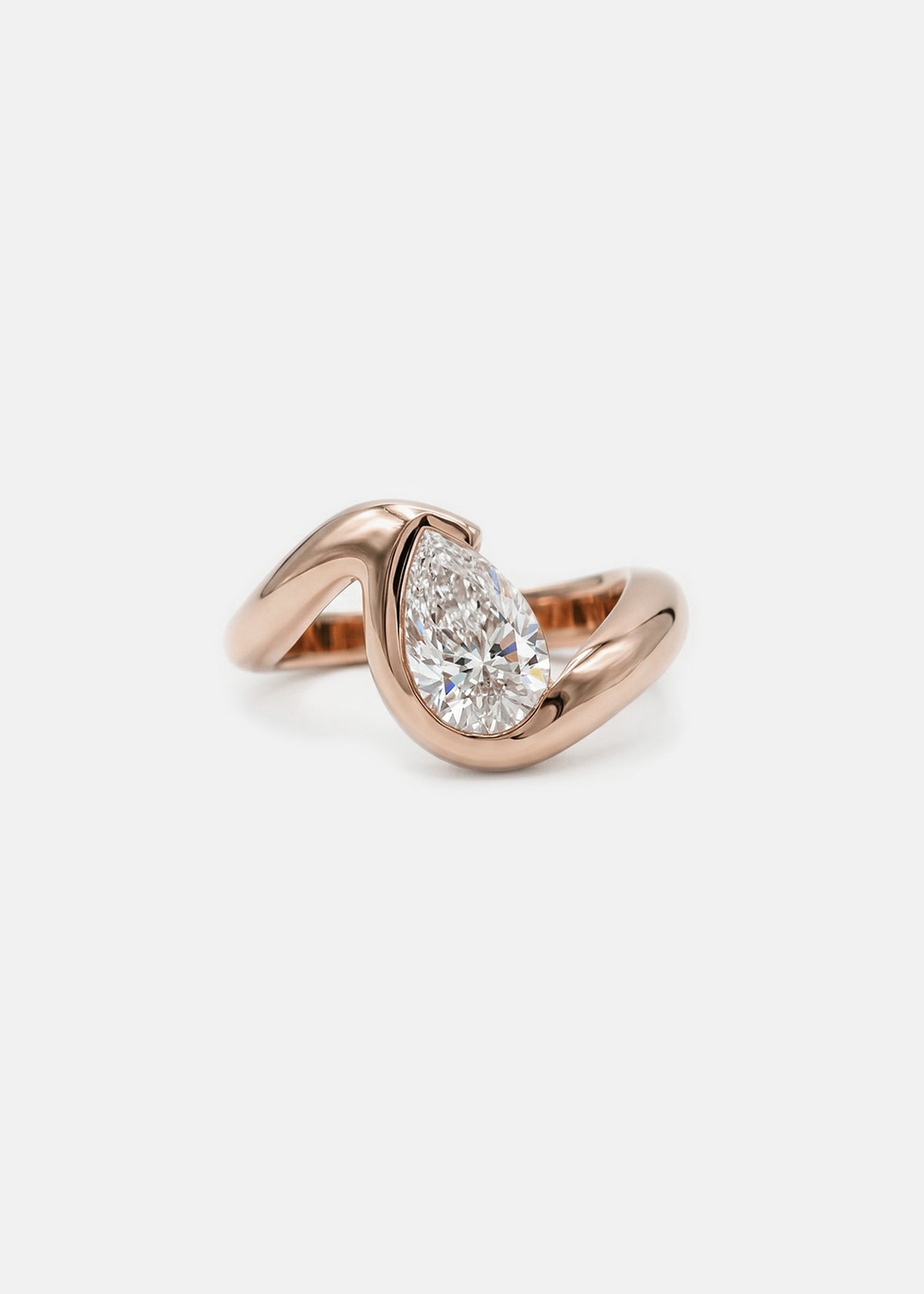 18k rose gold ring featuring a pear-cut diamond in a curved, wave-like setting.