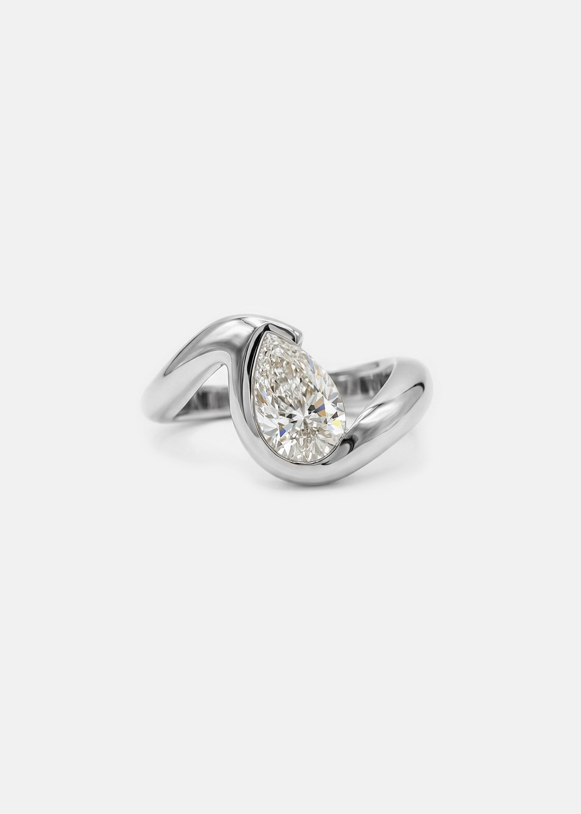 18k white gold ring featuring a pear-cut diamond in a curved, wave-like setting.