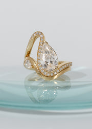 a gold wave pavé band with a pear cut diamond paired with gold wave band with a small pear cut diamond-18K yellow gold