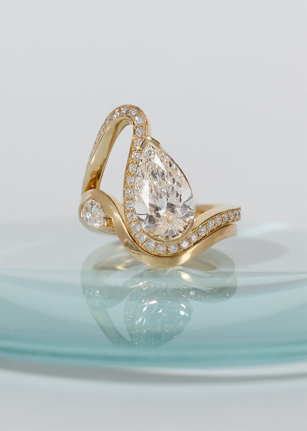 a gold wave pavé band with a pear cut diamond paired with gold wave band with a small pear cut diamond-18K yellow gold