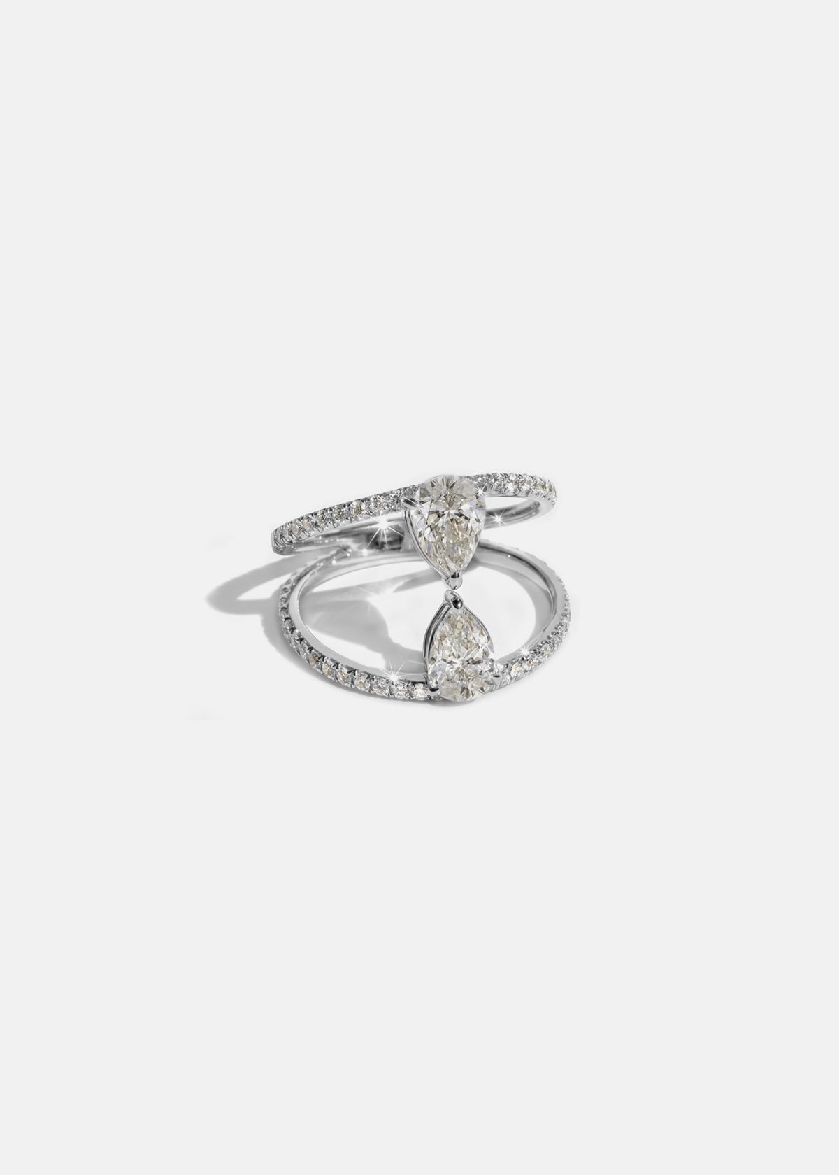 18k white gold dual engagement ring with two touching pear-cut diamonds facing opposite directions, with pavé diamonds along the band.