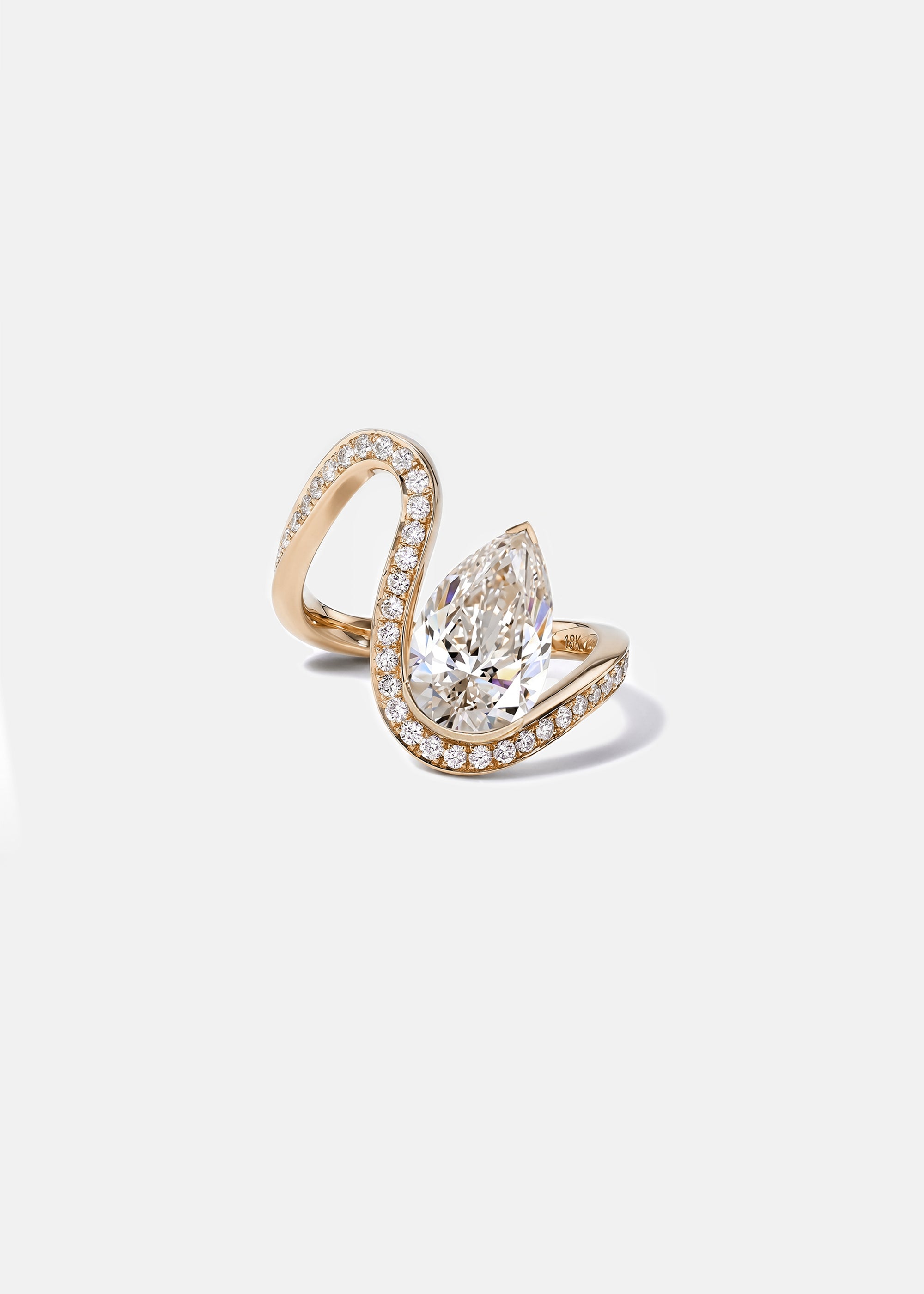 18k rose gold trace band with halo set of pavé diamonds along the wavy band and a floating pear cut diamond slightly tilted