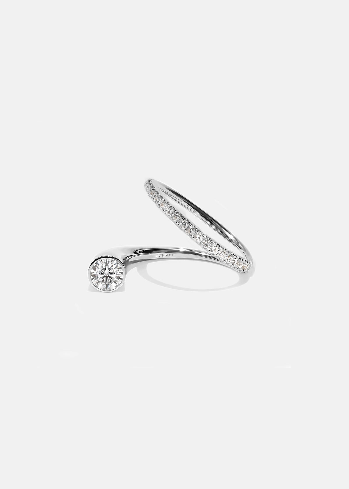 18k white gold sculptural bypass ring featuring a floating round cut diamond accented by an unexpected tilted band silhouette with pavé diamonds.