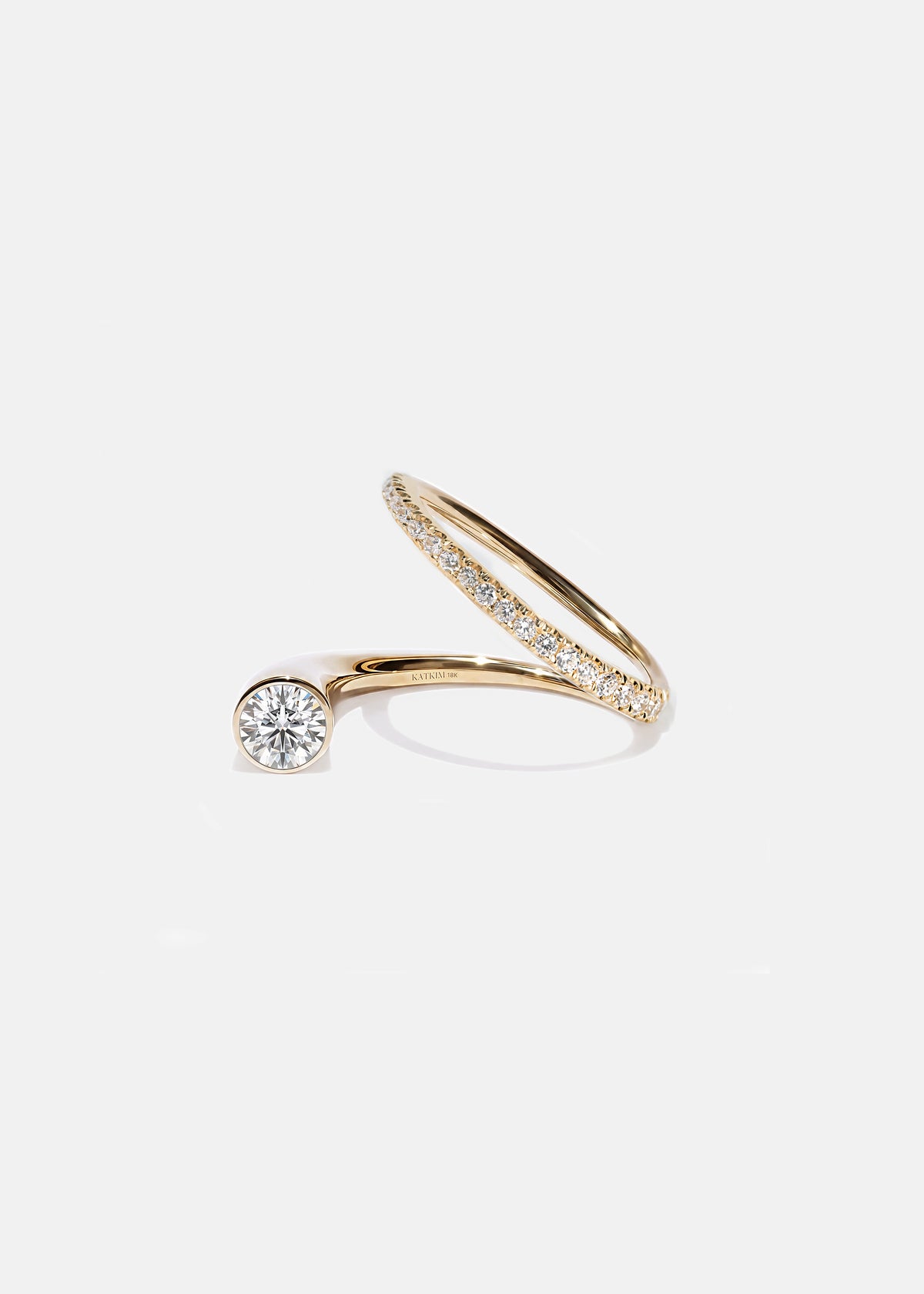 18k yellow gold sculptural bypass ring featuring a floating round cut diamond accented by an unexpected tilted band silhouette with pavé diamonds.