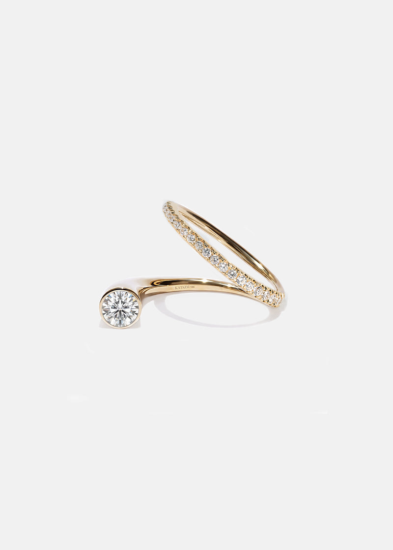 18k yellow gold sculptural bypass ring featuring a floating round cut diamond accented by an unexpected tilted band silhouette with pavé diamonds.