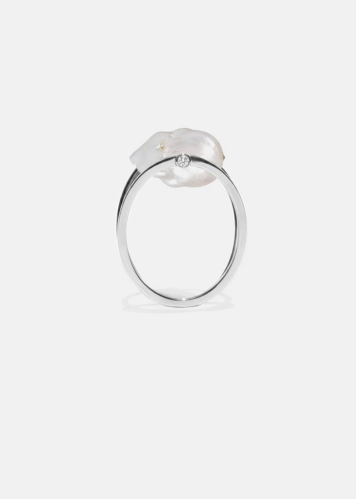 18k white gold architectural ring with a cultured freshwater Keshi pearl floating inside a circular open gold frame.