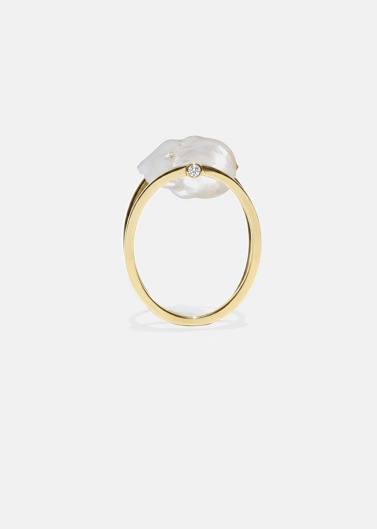 18k yellow gold architectural ring with a cultured freshwater Keshi pearl floating inside a circular open gold frame.