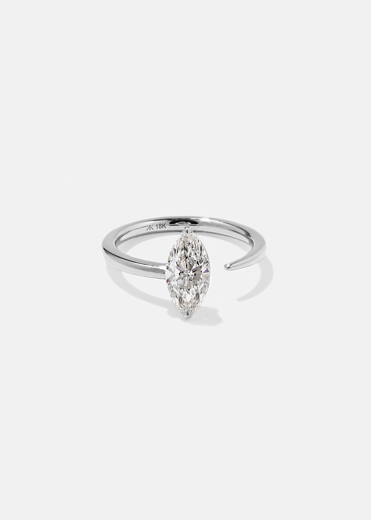 18k white gold engagement ring with a prong-set marquise diamond anchored on a fluid, tapering open band
