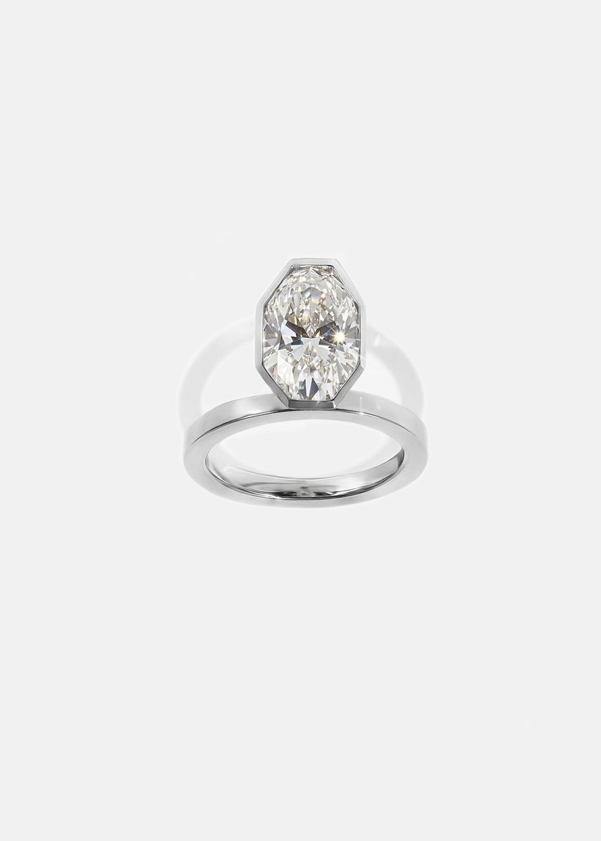 18k white gold engagement ring featuring an elevated floating oval cut diamond in a sculpted octagon bezel setting