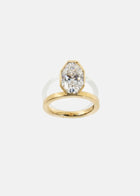 18k yellow gold engagement ring featuring an elevated floating oval cut diamond in a sculpted octagon bezel setting
