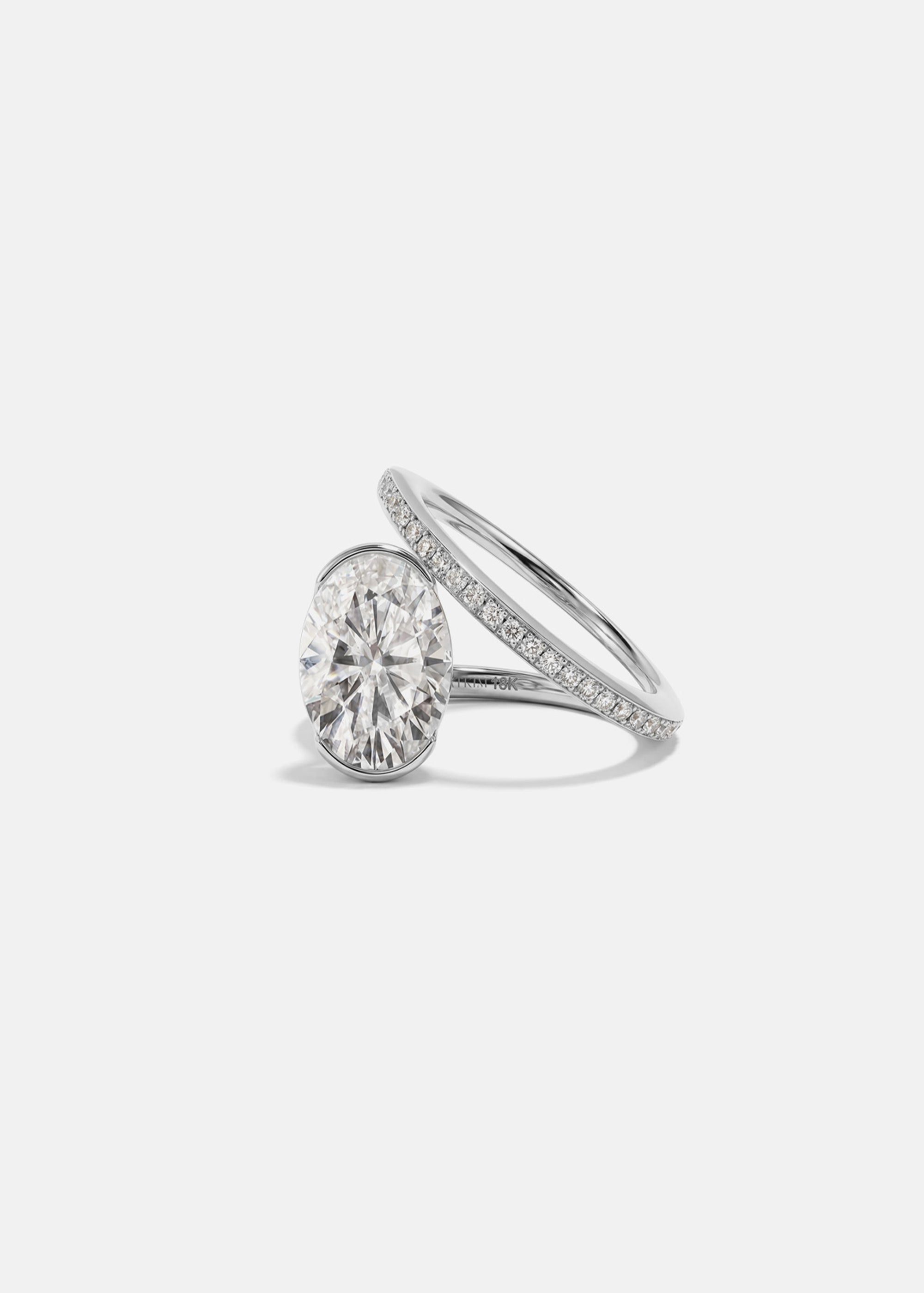 18k white gold bypass ring featuring a floating oval cut diamond and tapering micro-pavé band