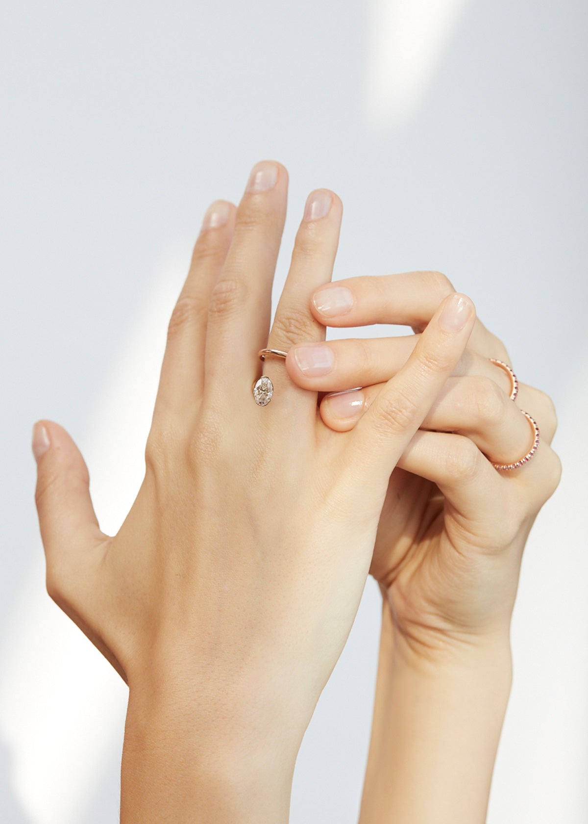 hand wearing 18k white gold Oval Crescendo Flare Ring with a floating oval diamond and tilted wrapping band