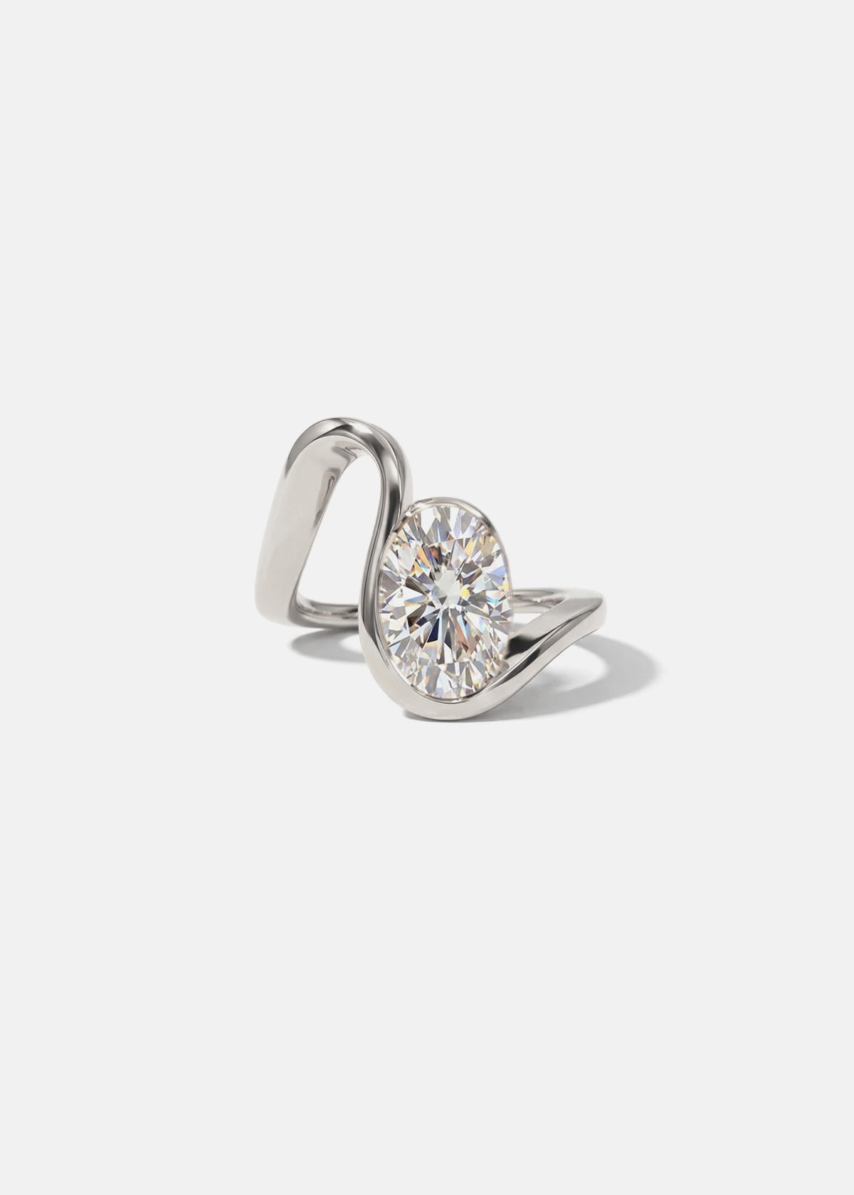 18k white gold ring with a wide wavy band resembling a ribbon nestling an oval cut diamond