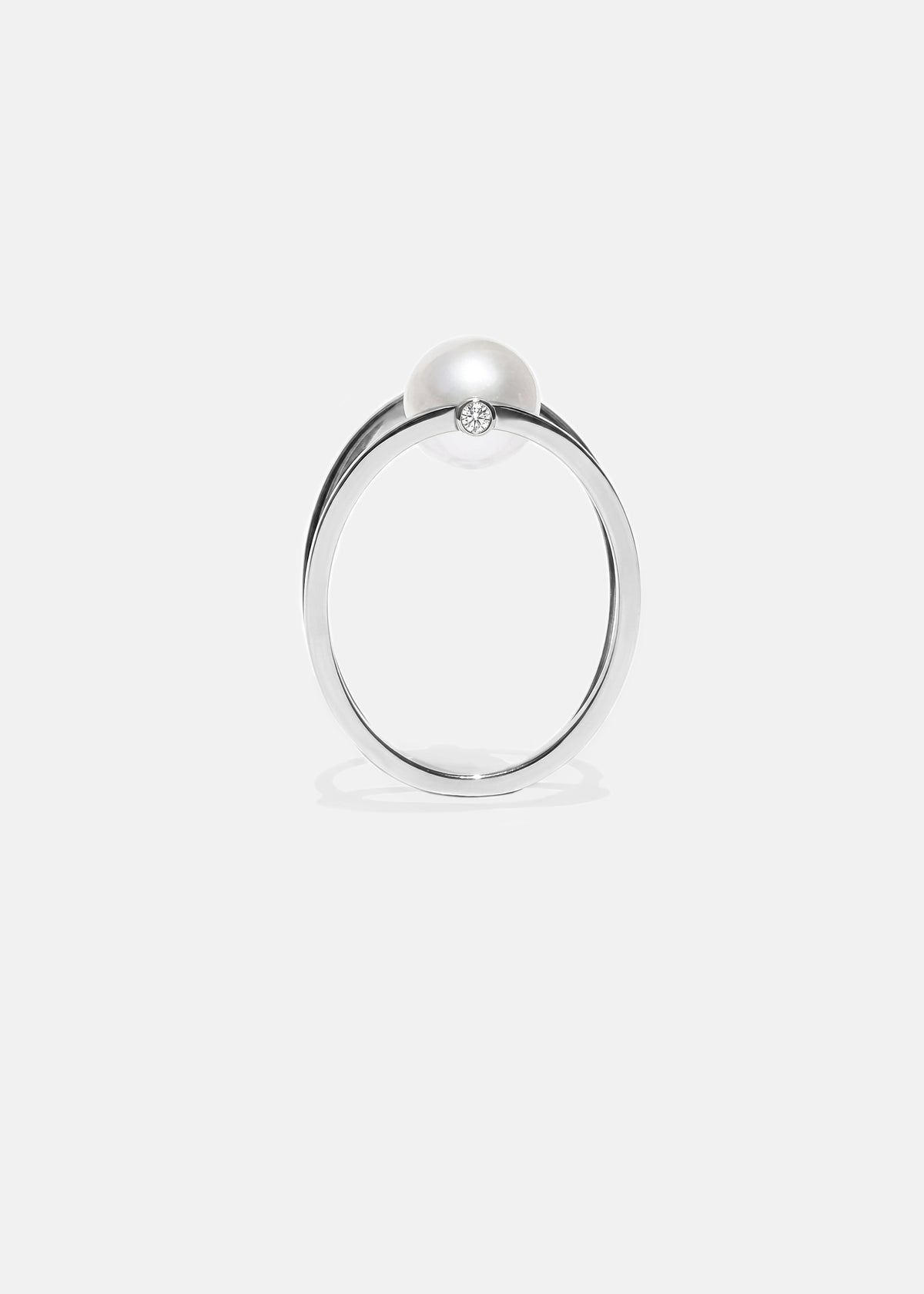 18k white gold architectural ring with a cultured freshwater pearl floating inside a circular open gold frame.