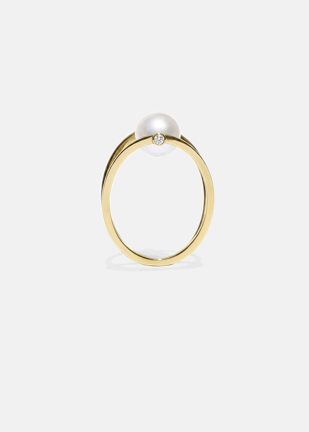 18k yellow gold architectural ring with a cultured freshwater pearl floating inside a circular open gold frame.