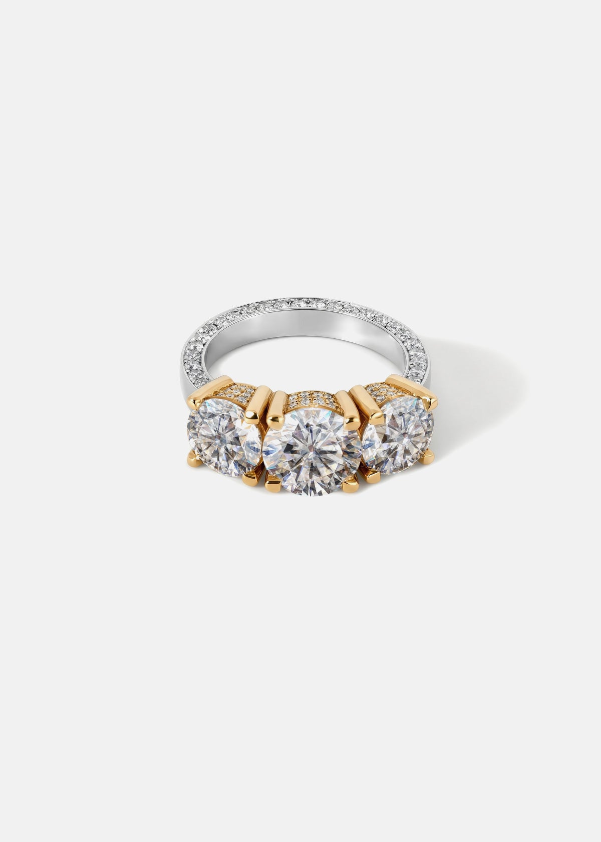 Three-stone diamond ring with a 18k white gold band and yellow gold straight prongs on a white background