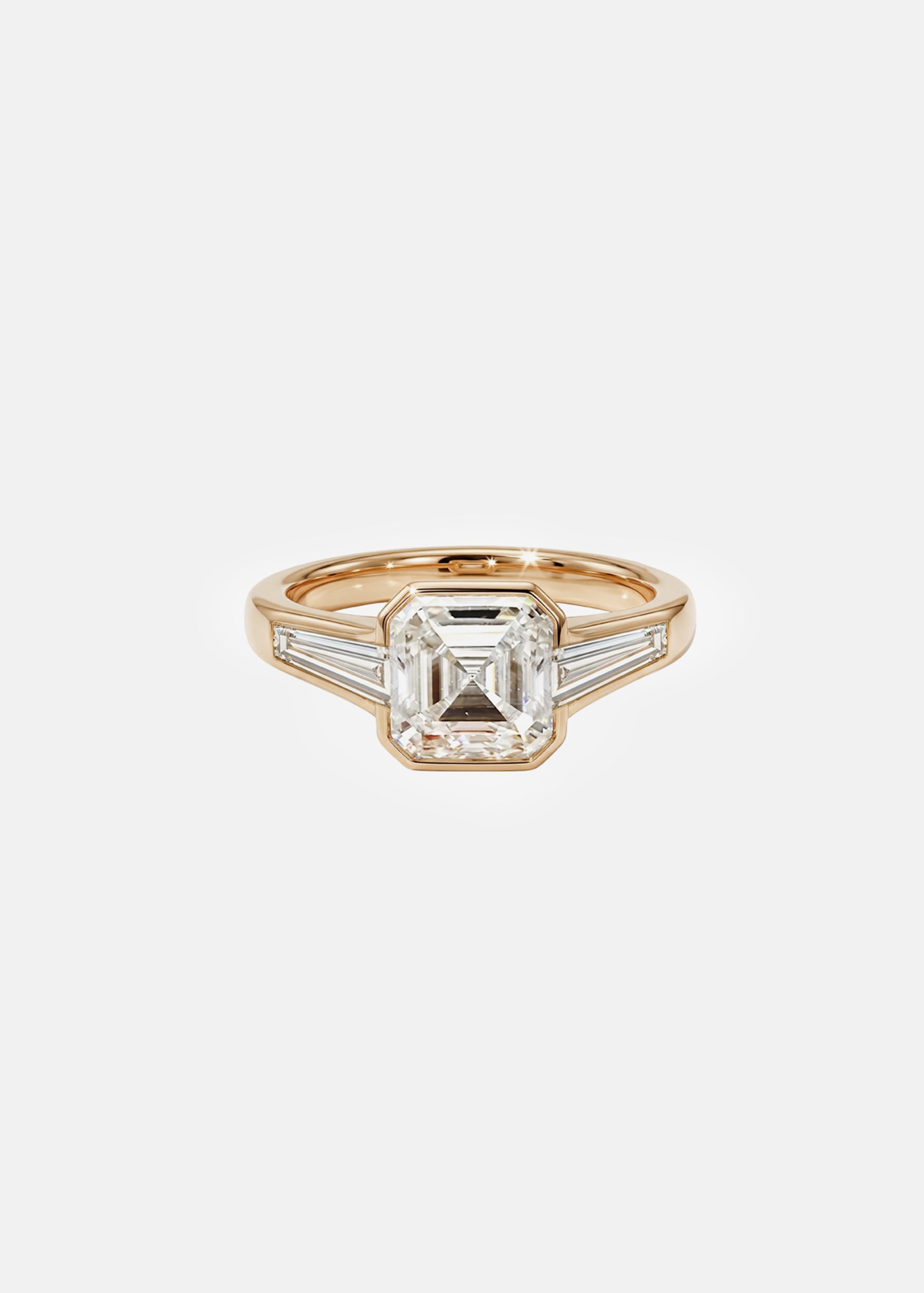 A 18k yellow gold ring featuring a central asscher-cut diamond flanked by two baguette-cut side stones