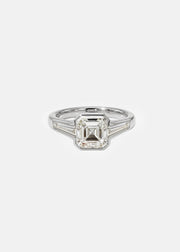 A 18k white gold ring featuring a central asscher-cut diamond flanked by two baguette-cut side stones