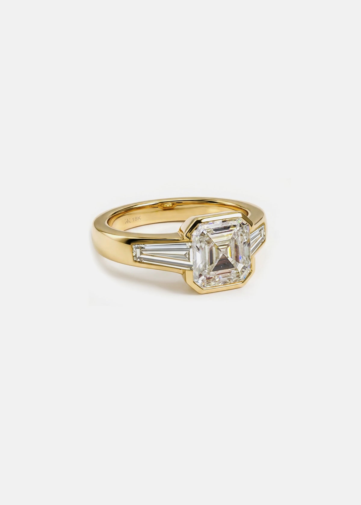 side view- 18k yellow gold ring featuring a central asscher-cut diamond flanked by two baguette-cut side stones