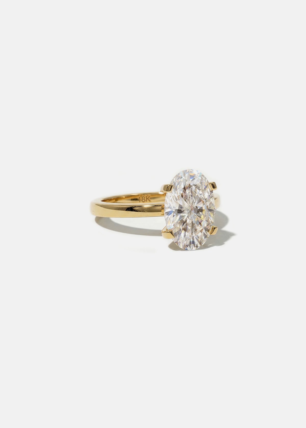 front view of a 18k yellow gold solitaire engagement ring featuring a oval cut diamond 