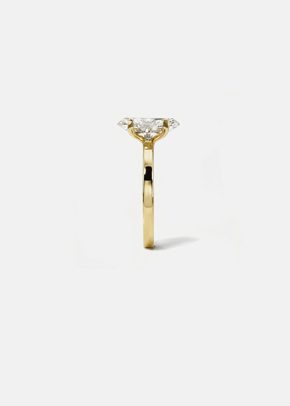 A 18k yellow gold solitaire engagement ring featuring a oval-cut diamond center stone, shown from a side profile view against a clean white background.