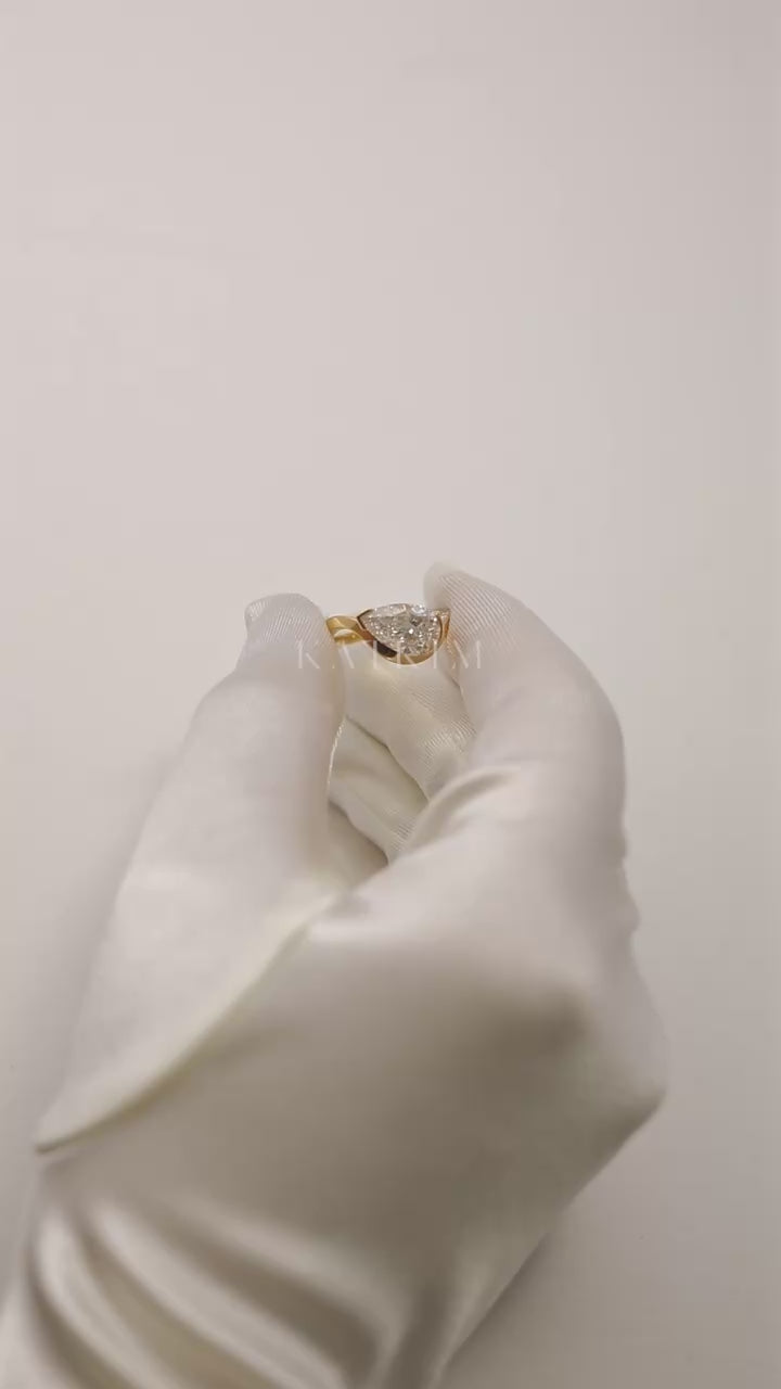 Video showcasing the 18k gold ring with a pear cut diamond and a pavé diamonds on top of the band