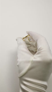 video showcasing a 18k yellow gold open wrap ring featuring a pear-cut diamond and a pavé diamonds along the band.