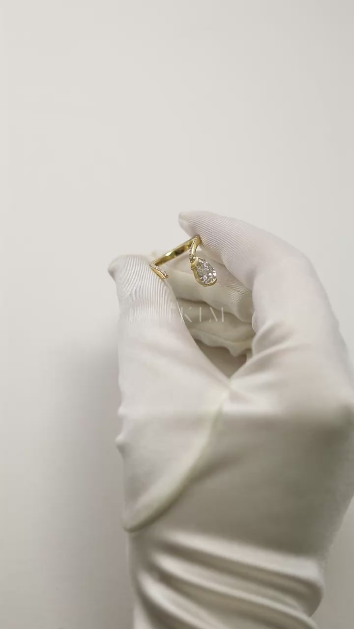 video showcasing a 18k yellow gold open wrap ring featuring a pear-cut diamond and a pavé diamonds along the band.