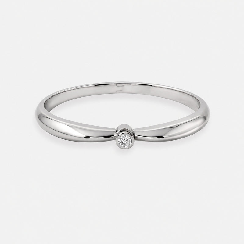 A gold bracelet with a single diamond bezel set in the center, from the Éternal Collection.